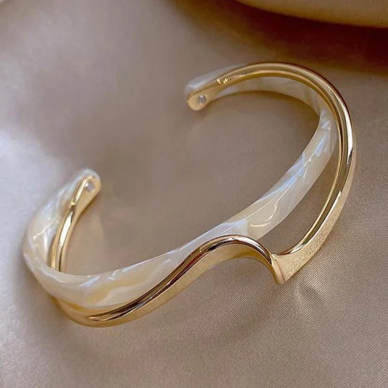 Gold open cuff bracelet with sculptural curves and translucent faceted detail