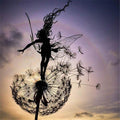 Black metal garden ornament with a winged fairy on a dandelion-style flower
