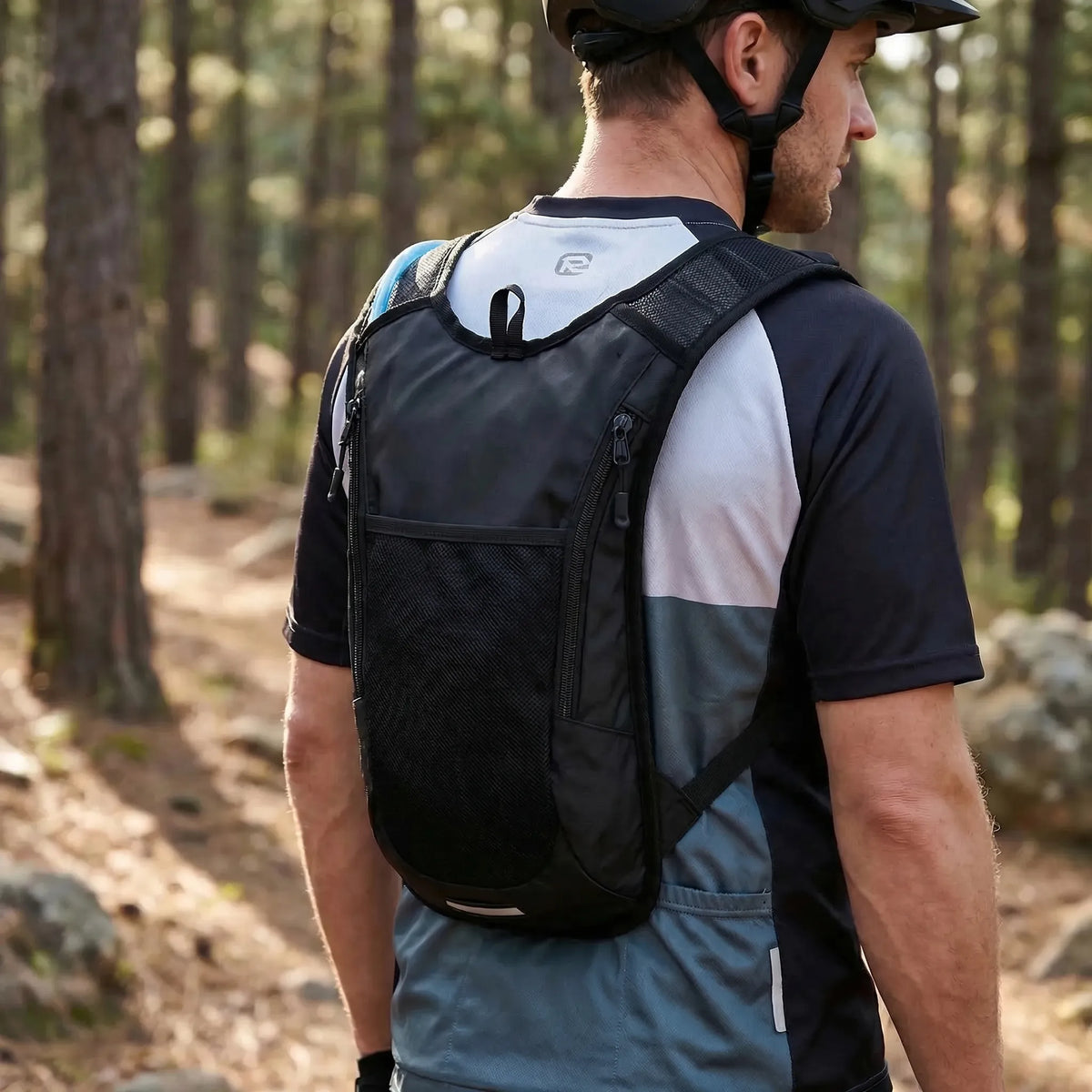 Black hydration backpack with translucent water bladder and blue drinking tube
