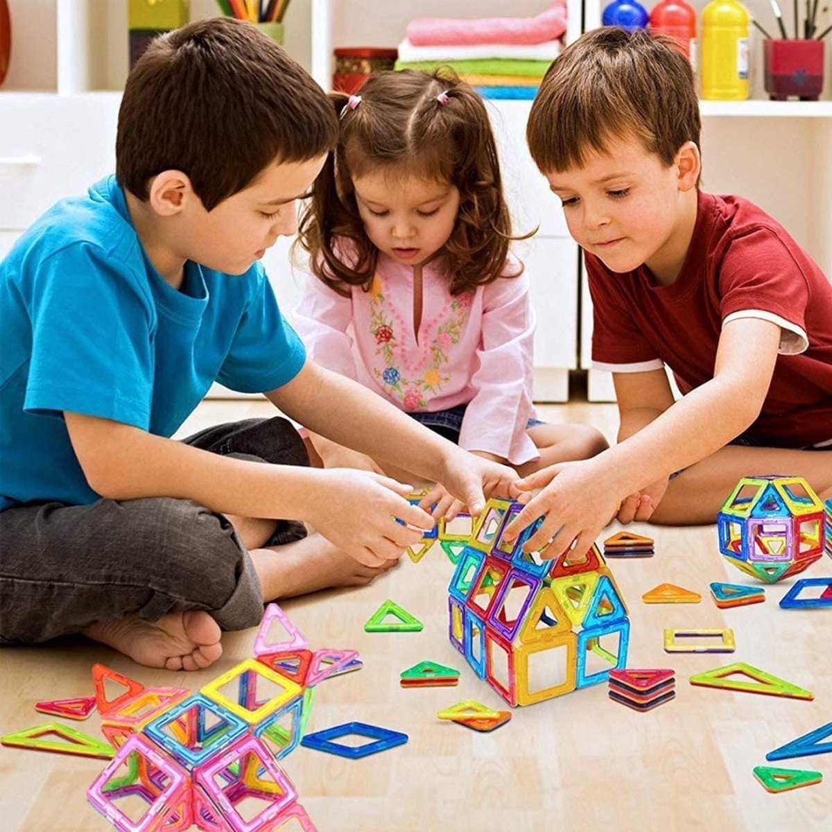 Colourful magnetic building tiles arranged into houses, towers and vehicles