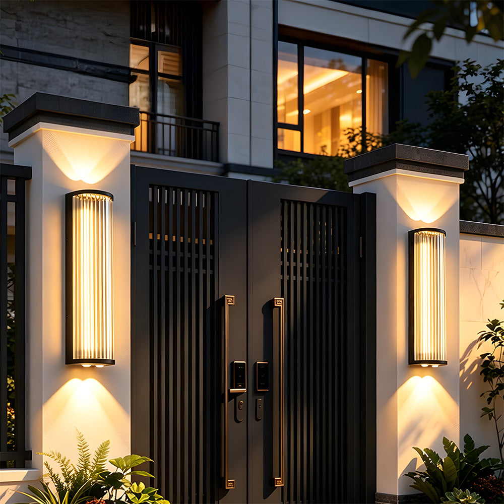 Black outdoor wall light with vertical glass shade and up and down illumination