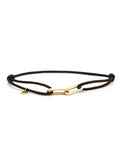 Black cord bracelet with yellow-gold-tone link closure and round charm