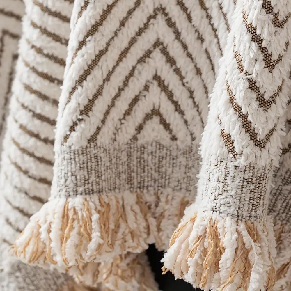 Herringbone sofa cover with textured pattern and fringed edge