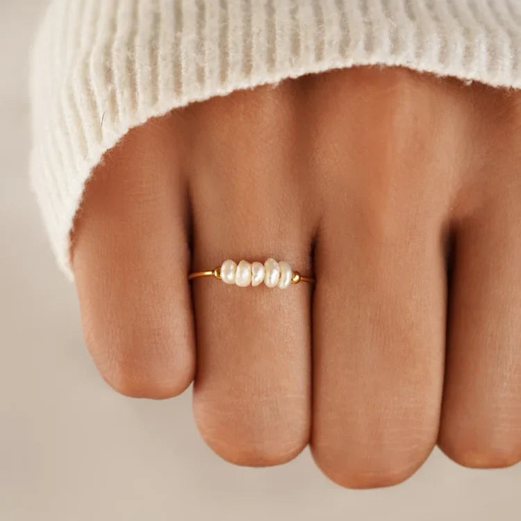 Gold-tone ring with a row of white pearl details