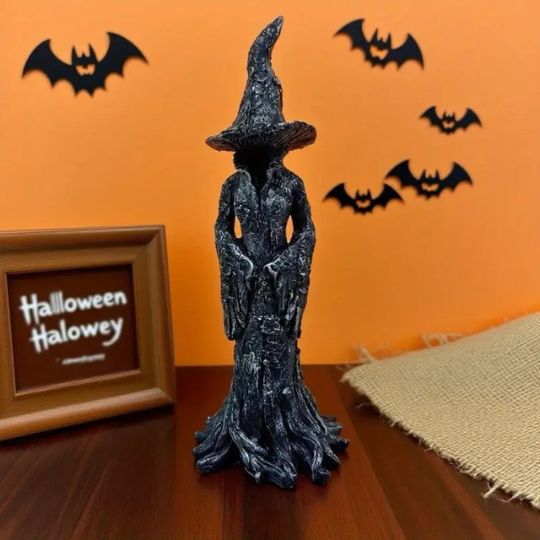 Black Halloween witch figurine with pointed hat and flowing sculpted robe