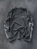 Long sleeve crew neck top with white script lettering on the sleeves