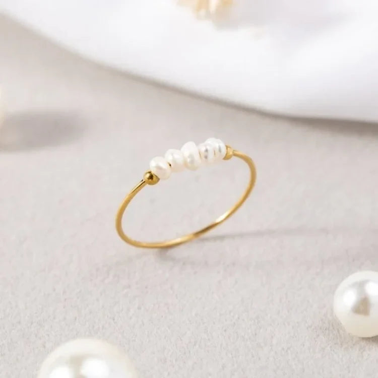 Gold-tone ring with a row of white pearl details