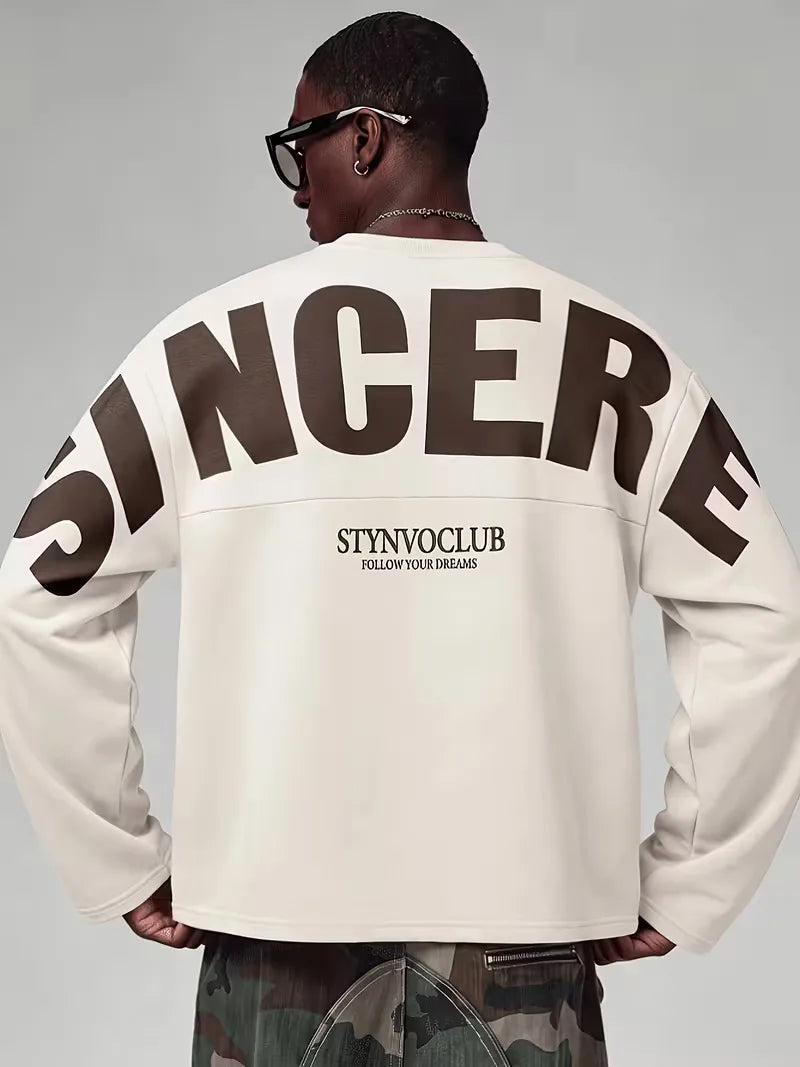 Beige oversized long sleeve top with bold dark text print on the back and sleeves