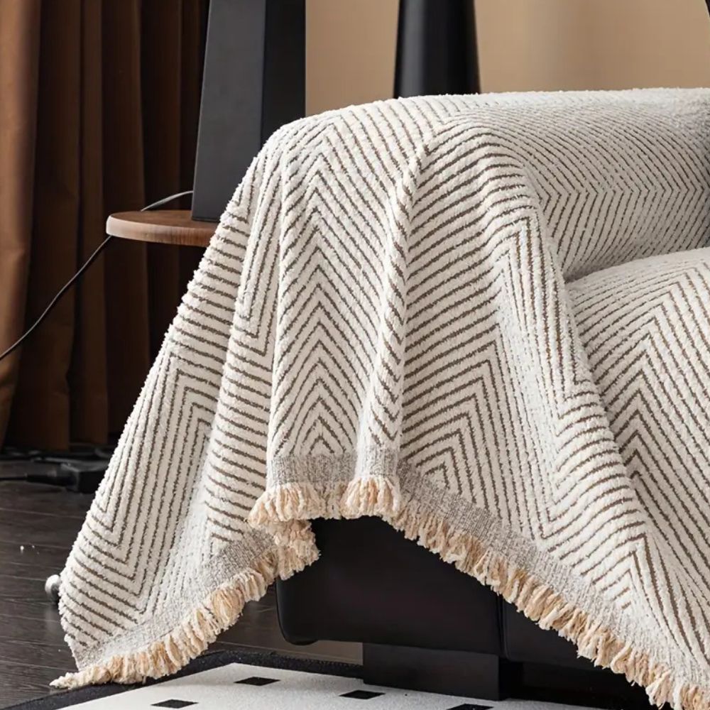 Herringbone sofa cover with textured pattern and fringed edge