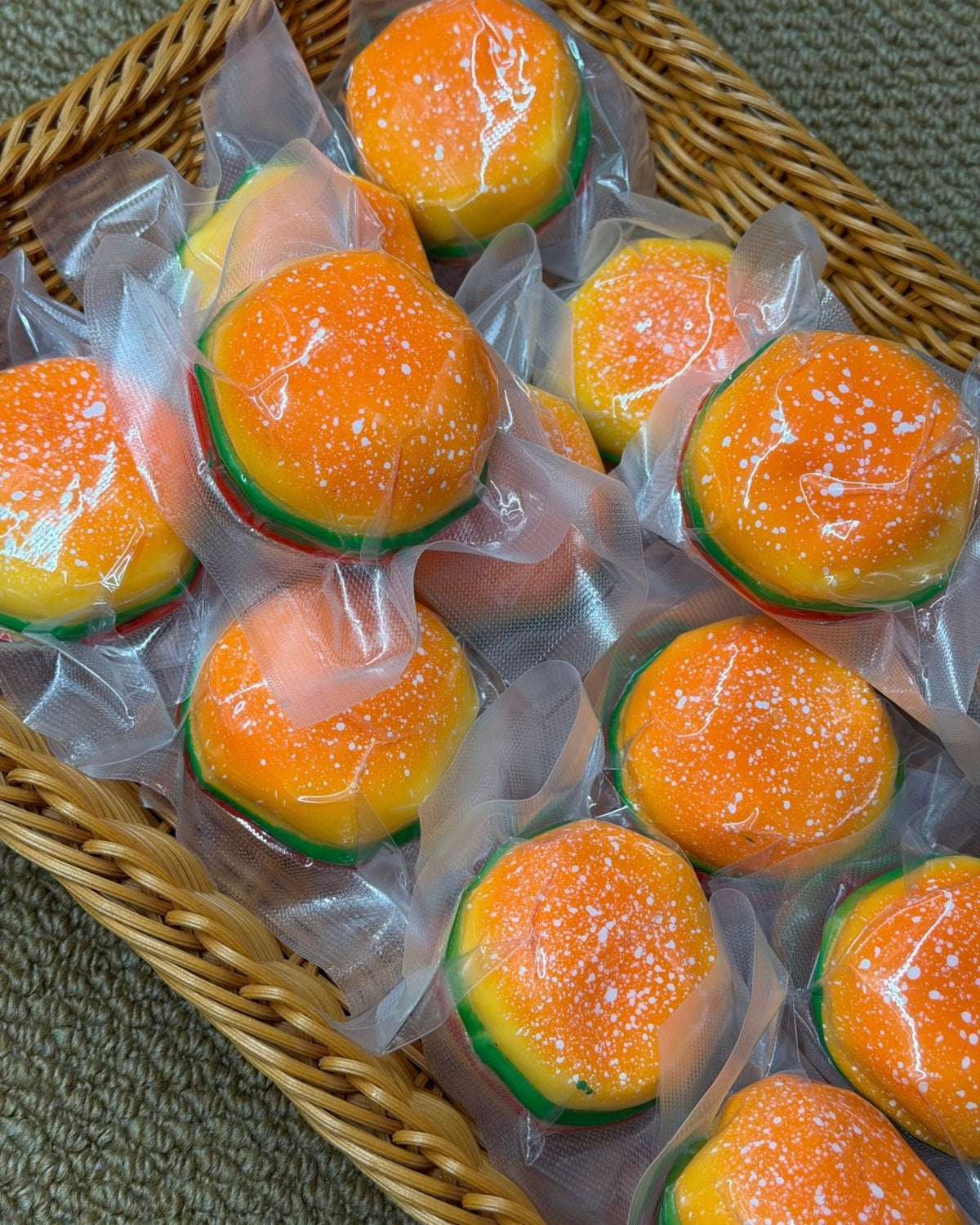 Orange burger-shaped squishy stress ball with white speckles and colourful layers
