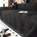 Herringbone sofa cover with textured pattern and fringed edge