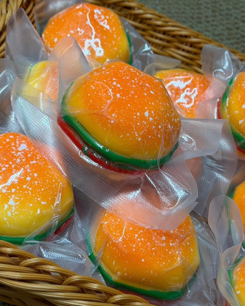 Orange burger-shaped squishy stress ball with white speckles and colourful layers
