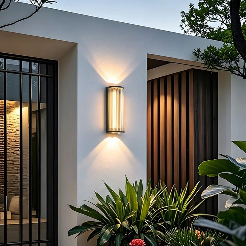 Black outdoor wall light with vertical glass shade and up and down illumination