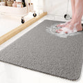 Textured non-slip shower mat beside a bathtub