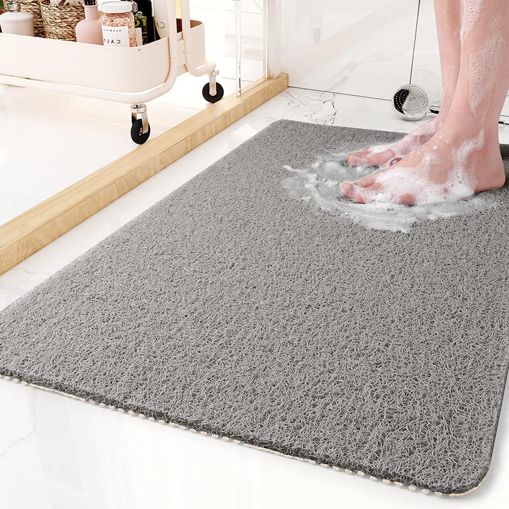 Textured non-slip shower mat beside a bathtub
