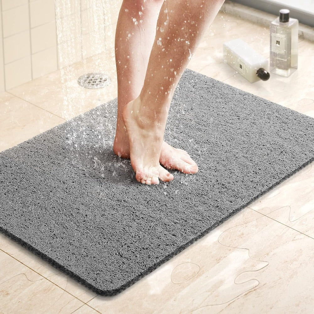 Textured non-slip shower mat beside a bathtub