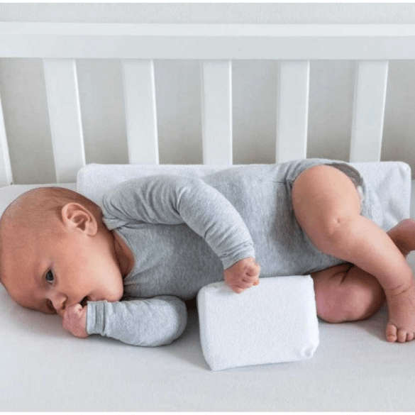 Infant sleep positioning pillow with central padded area and raised side supports