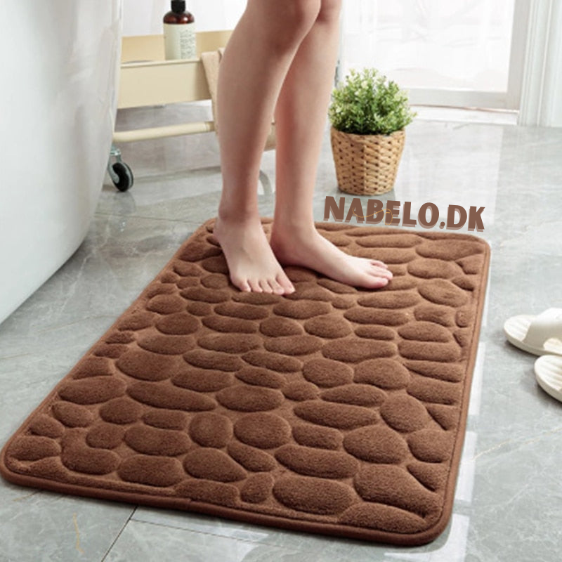 Rectangular textured bathroom mat with a raised cobblestone pattern