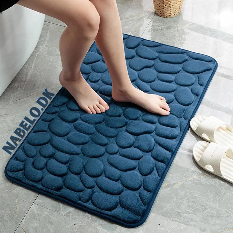 Rectangular textured bathroom mat with a raised cobblestone pattern