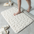 Rectangular textured bathroom mat with a raised cobblestone pattern