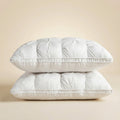Tufted rectangular bed pillows with piped edges stacked on a bed