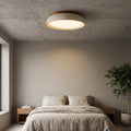 Round flush mount ceiling light with travertine finish and wood-effect trim