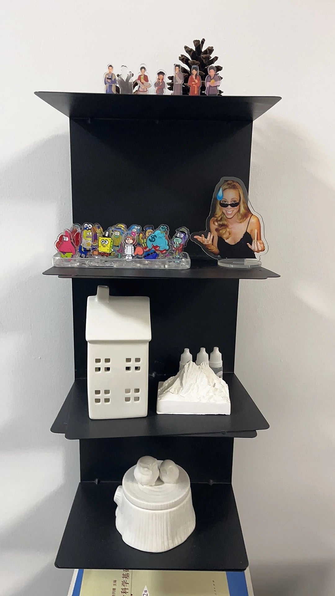 Vertical metal bookshelf with open shelves and a rectangular base