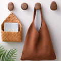 Pebble-shaped wooden decorative wall hooks mounted on a white wall