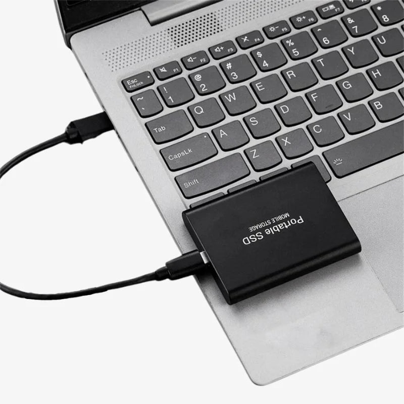 Portable SSD external drive connected to a laptop with USB cable