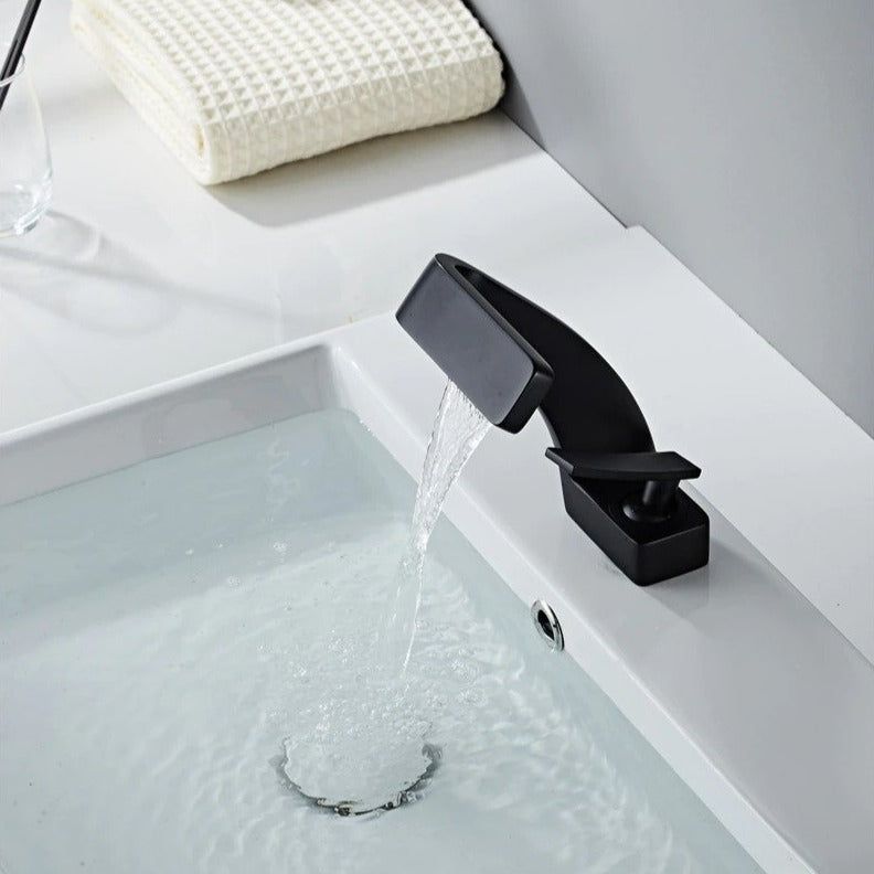 Curved bathroom basin faucet with waterfall-style spout and single lever