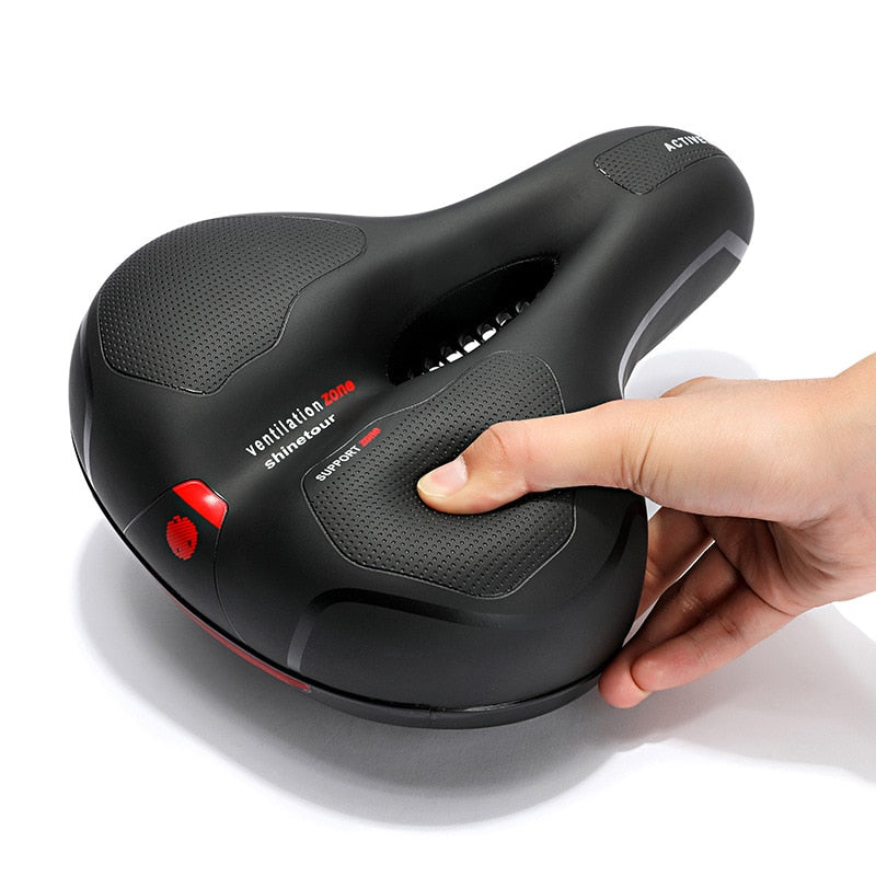 Ergonomic bicycle saddle with textured support panels, ventilation zone and suspension springs