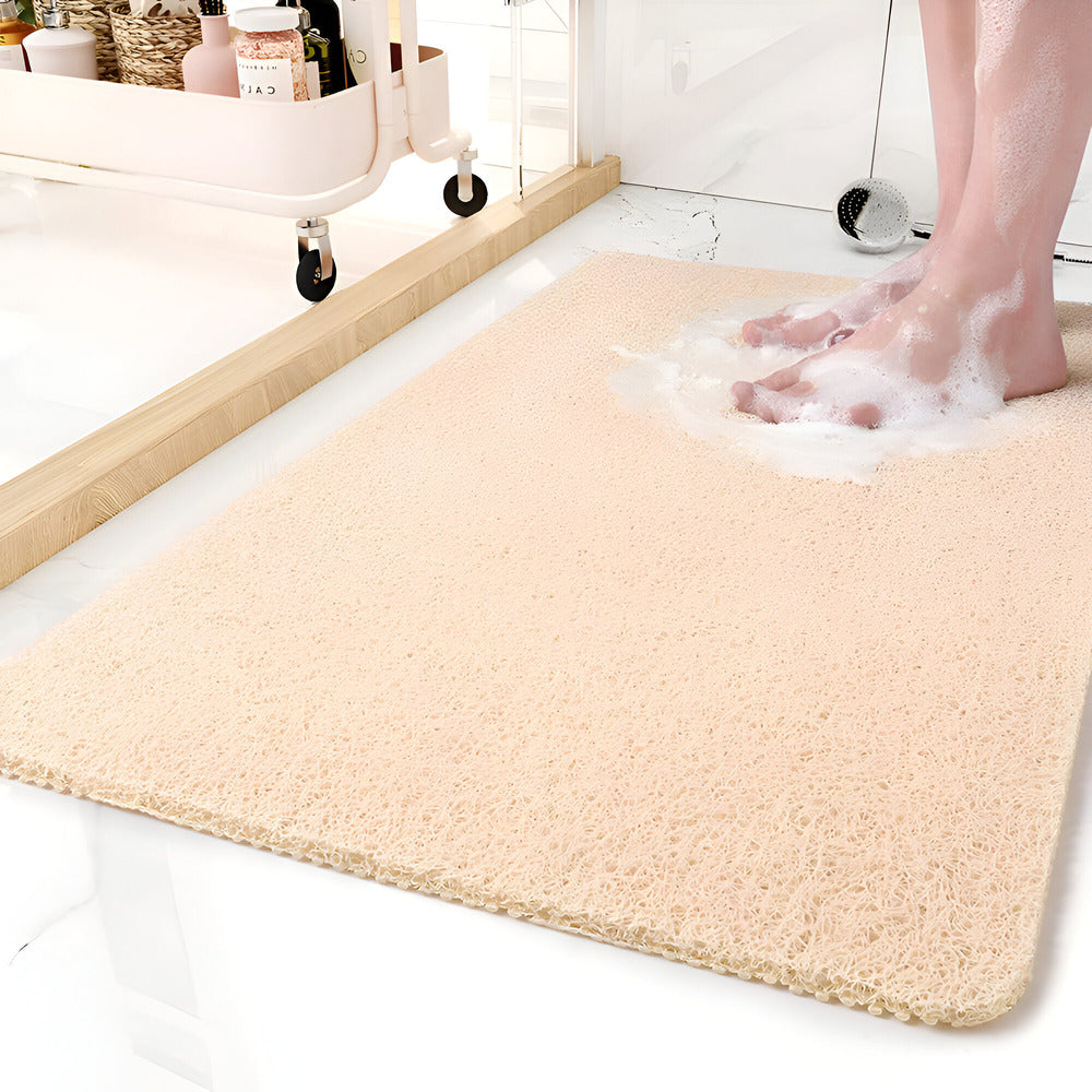 Textured rectangular bath mat with rounded corners on a bathroom floor