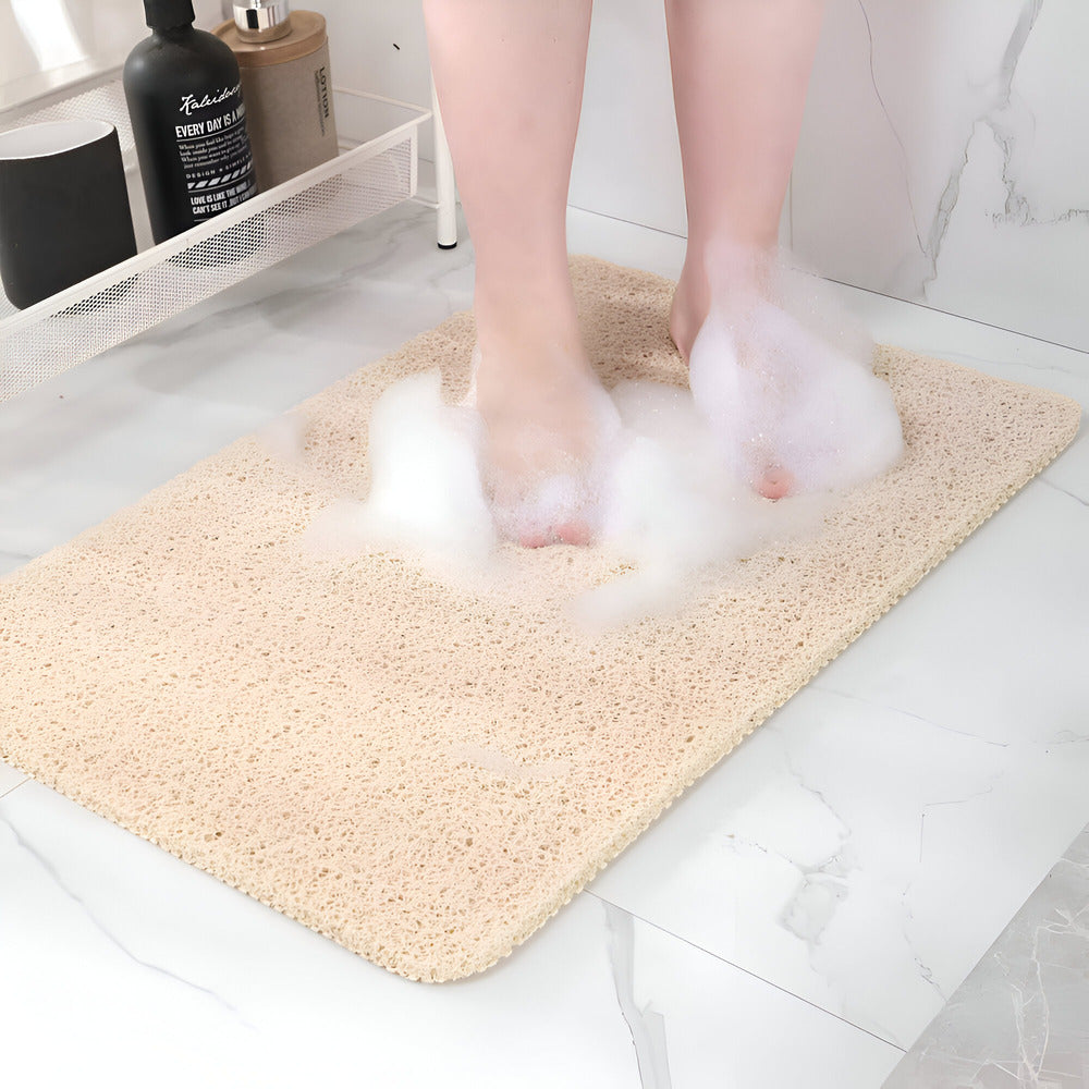Textured rectangular bath mat with rounded corners on a bathroom floor