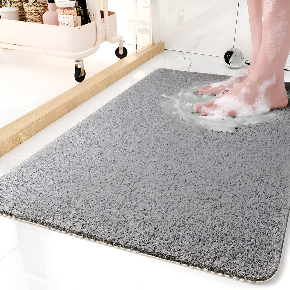 Textured rectangular bath mat with rounded corners on a bathroom floor