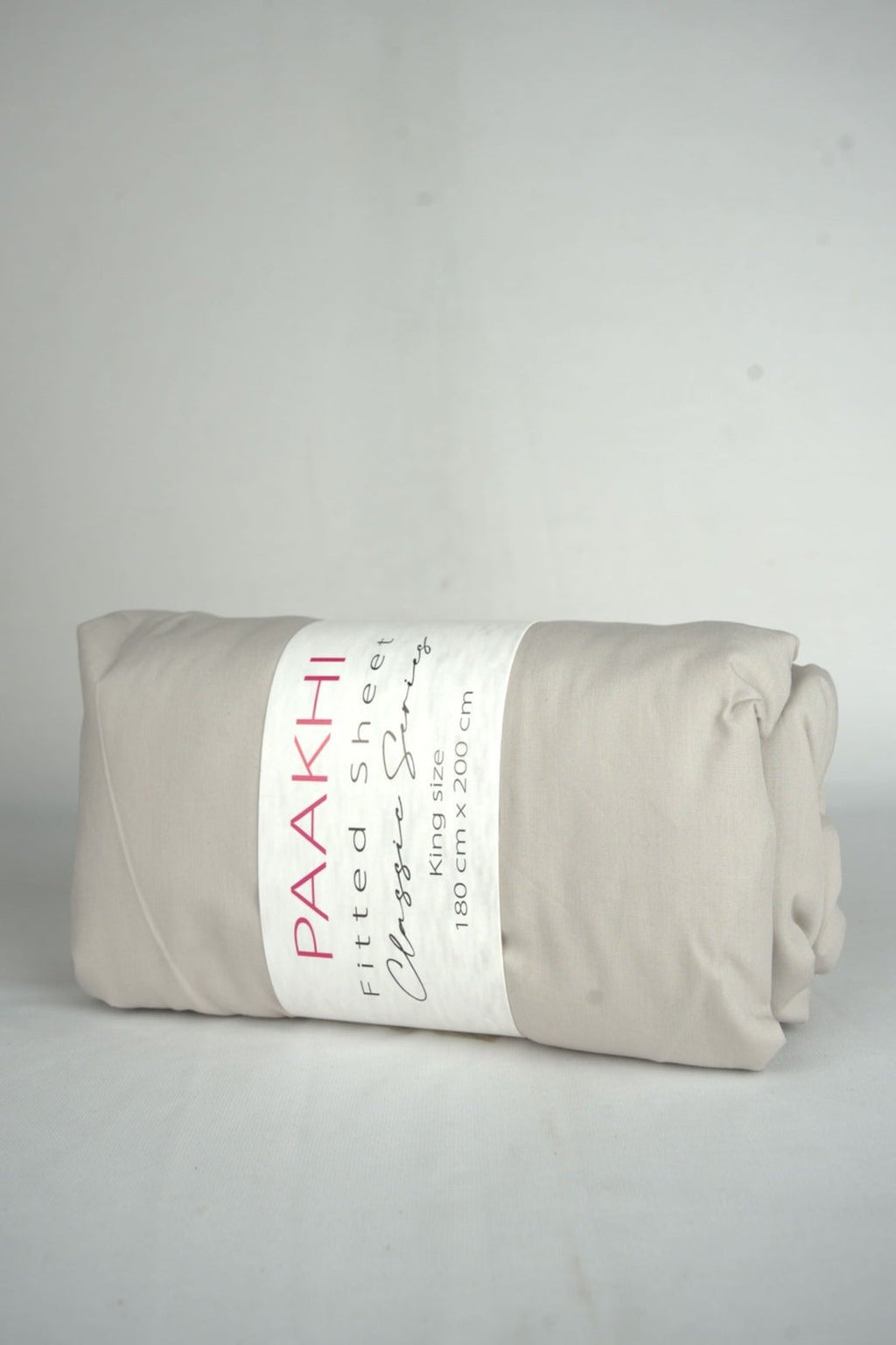 Rolled beige king size fitted sheet with packaging label