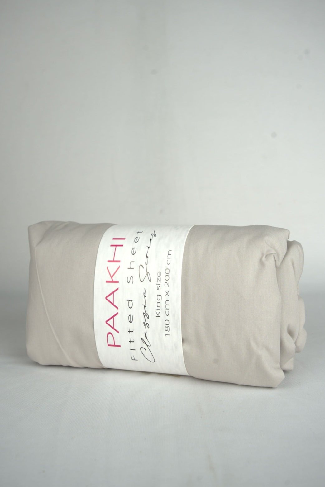 Rolled beige king size fitted sheet with packaging label