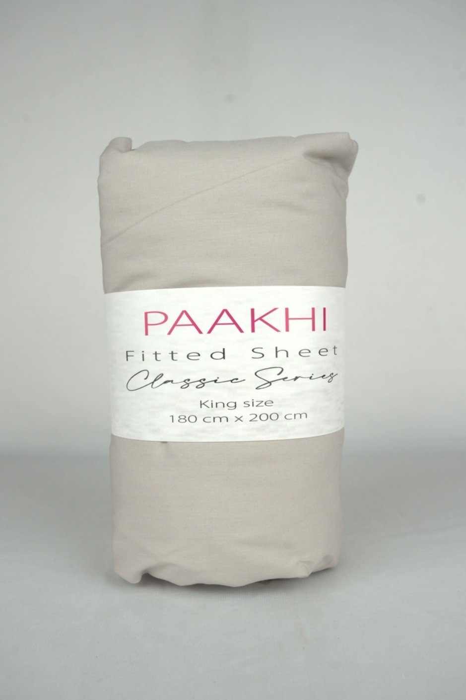 Rolled beige king size fitted sheet with packaging label