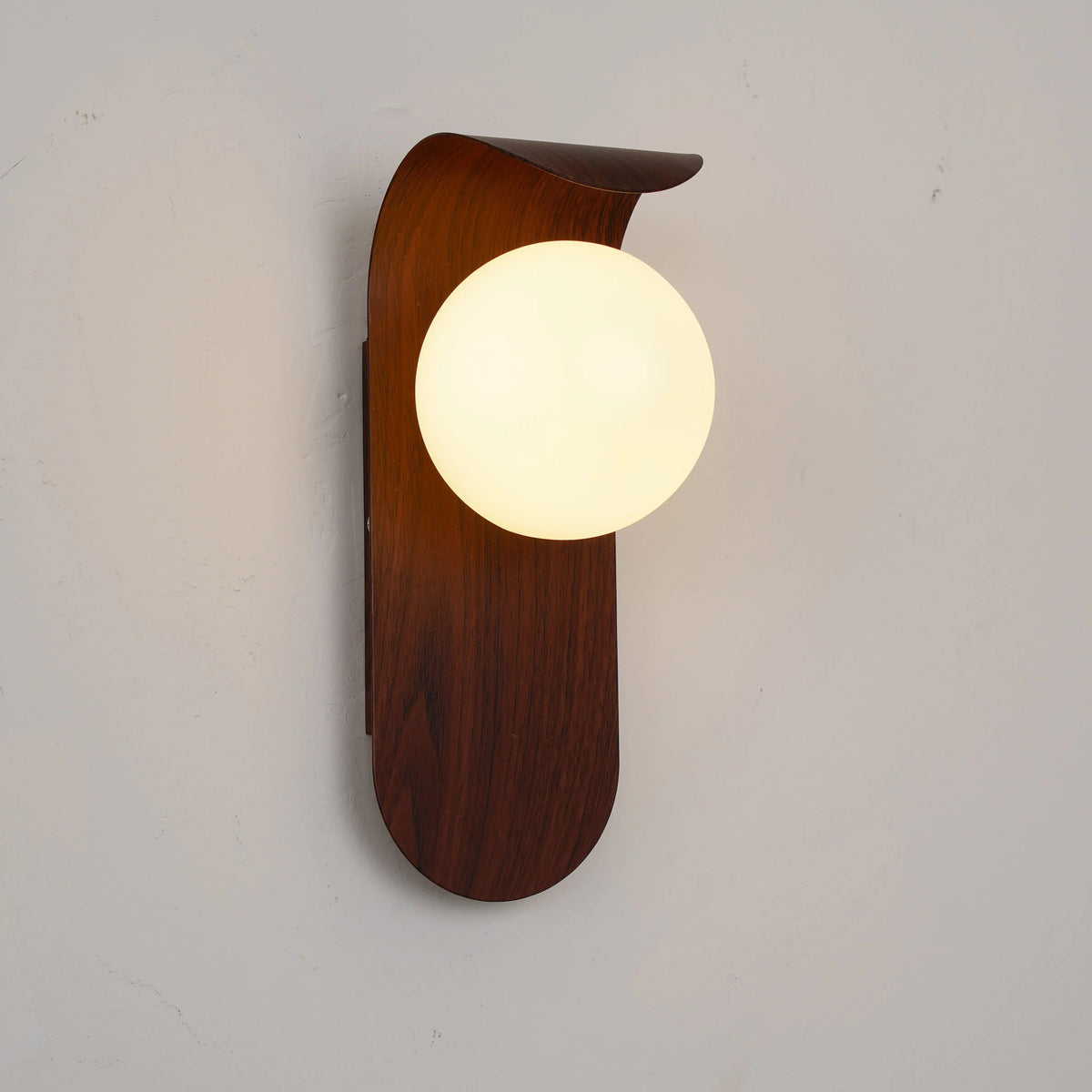 Japandi LED wall light with round globe shade and curved wood-effect panel