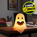 White ghost-shaped table lamp with a warm glow and an open book design