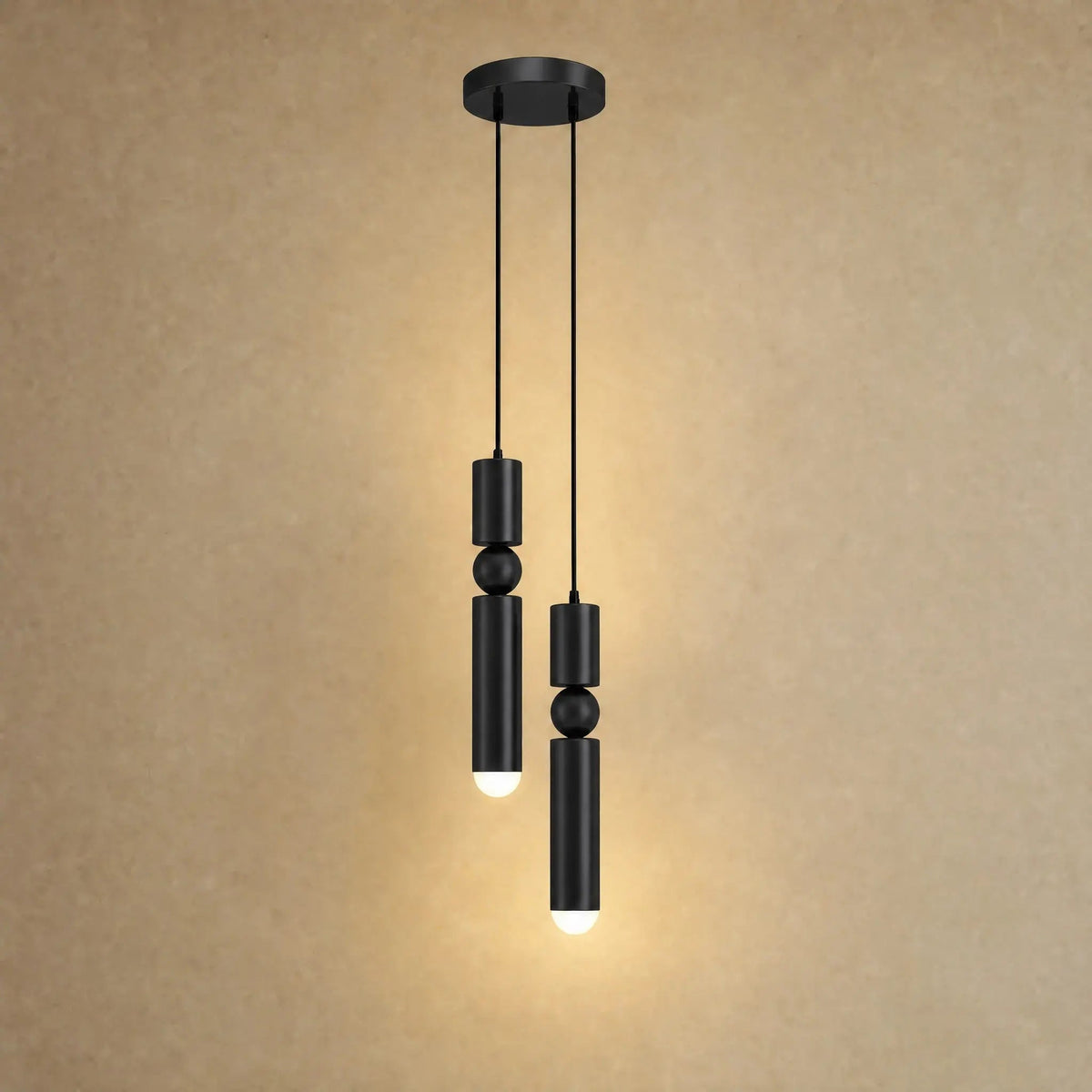 Gold pendant light with two cylindrical hanging elements and spherical details