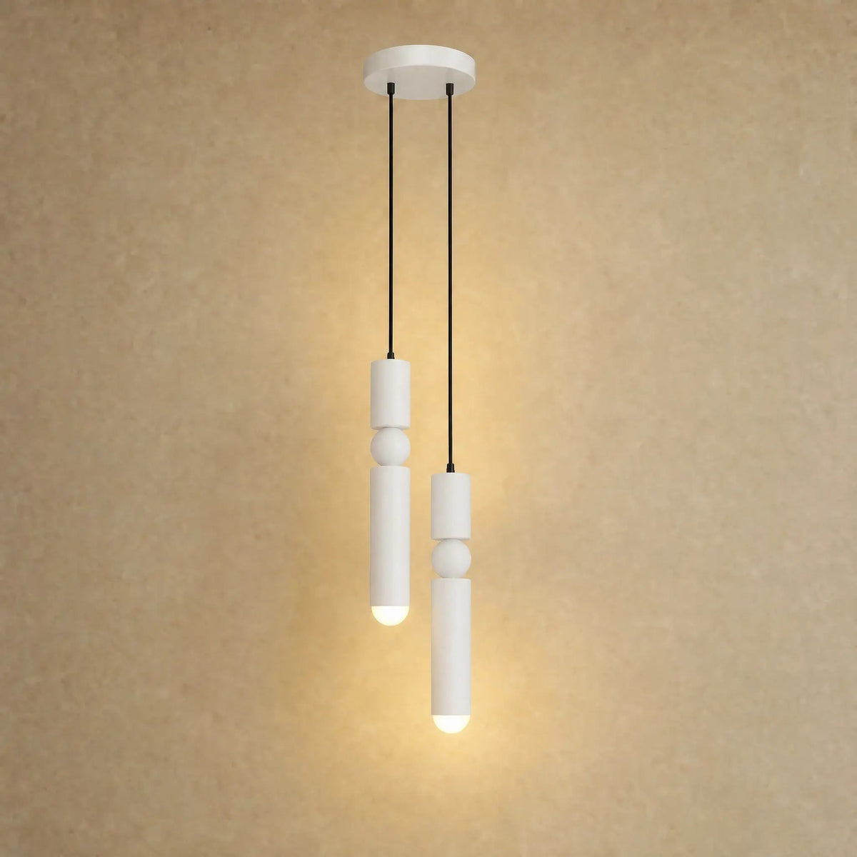 Gold pendant light with two cylindrical hanging elements and spherical details