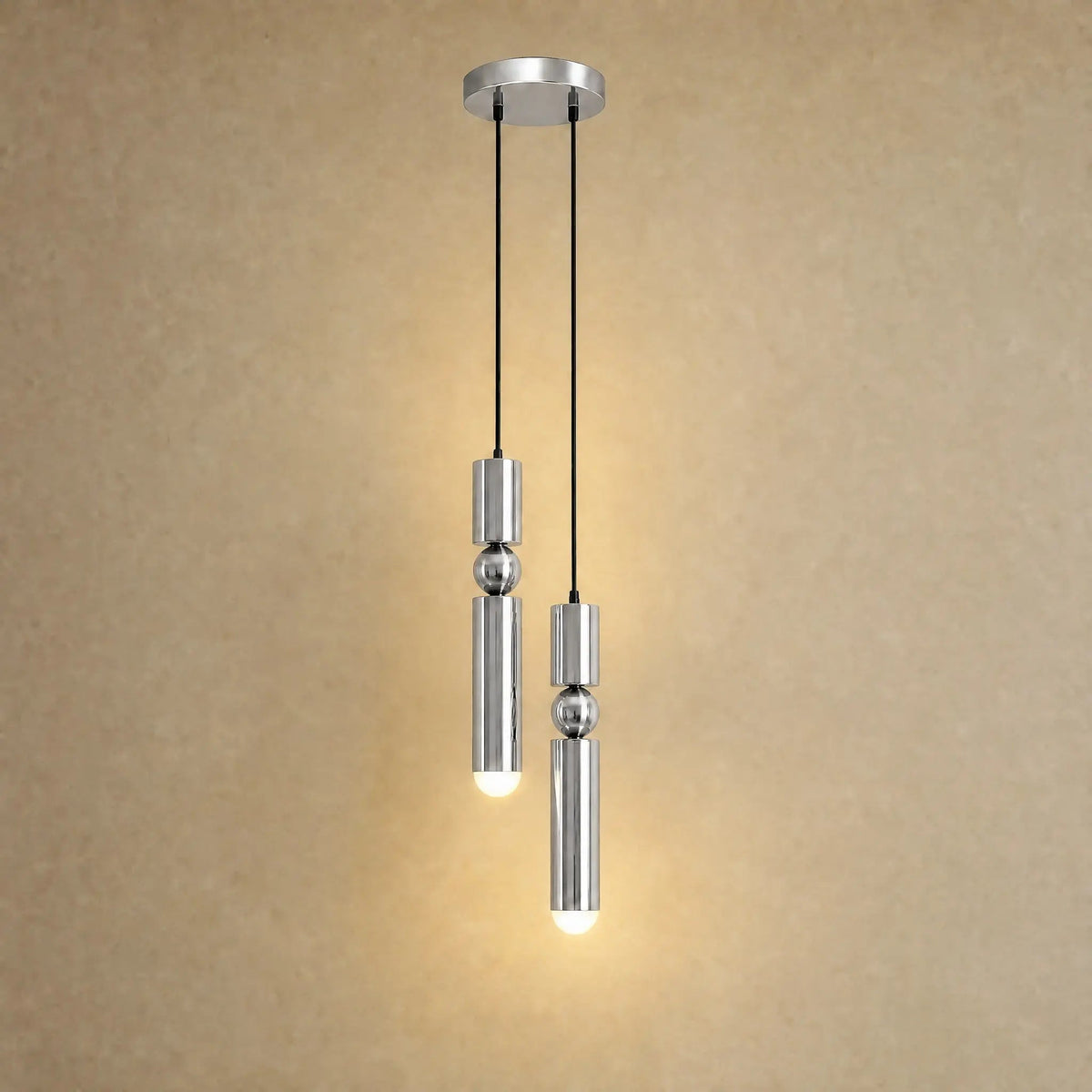 Gold pendant light with two cylindrical hanging elements and spherical details