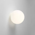 White frosted glass globe LED wall sconce mounted on a wall