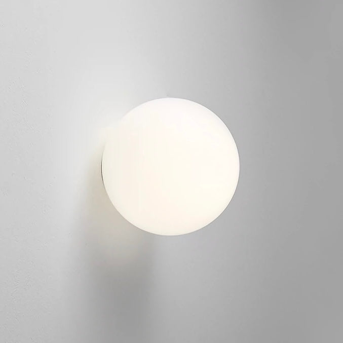 White frosted glass globe LED wall sconce mounted on a wall