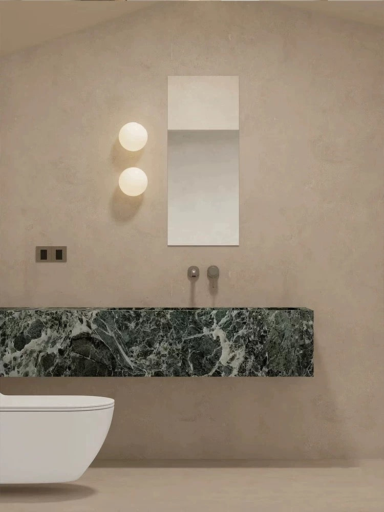 White frosted glass globe LED wall sconce mounted on a wall