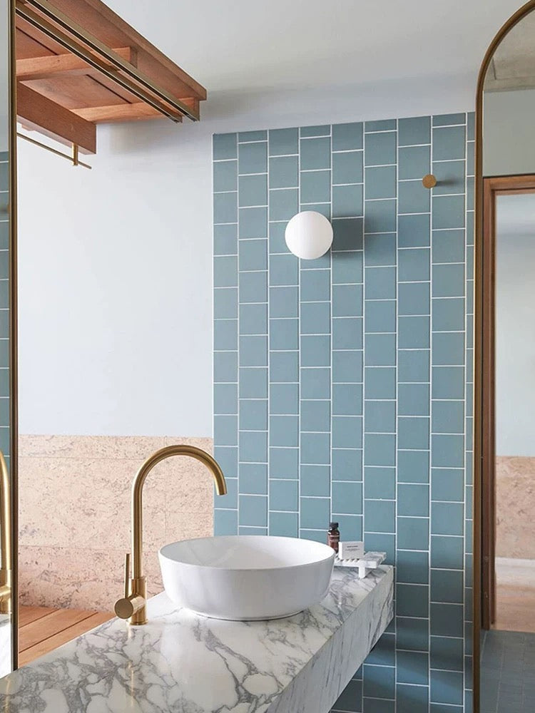White frosted glass globe LED wall sconce mounted on a wall
