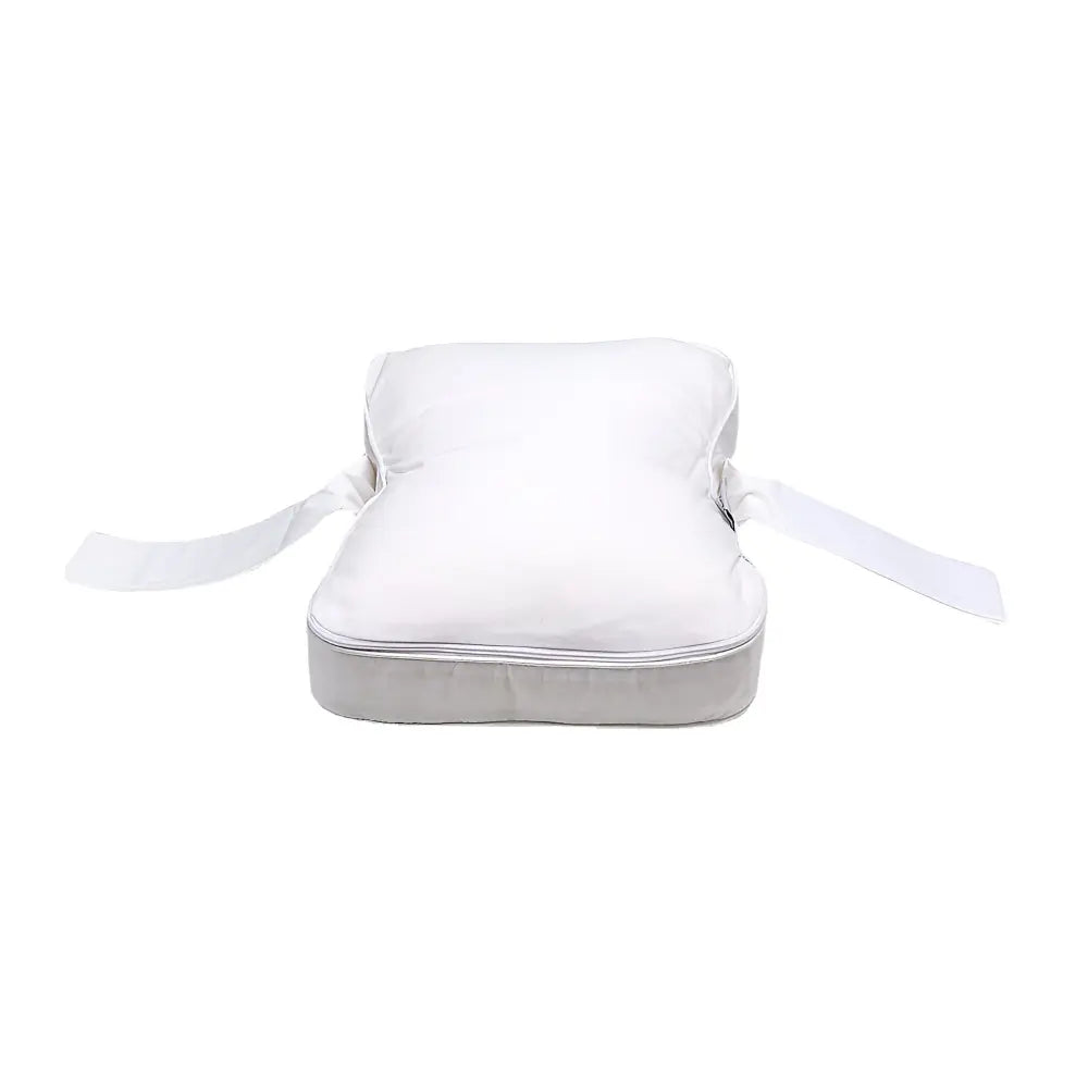 Contoured knee pillow with securing strap positioned between the legs