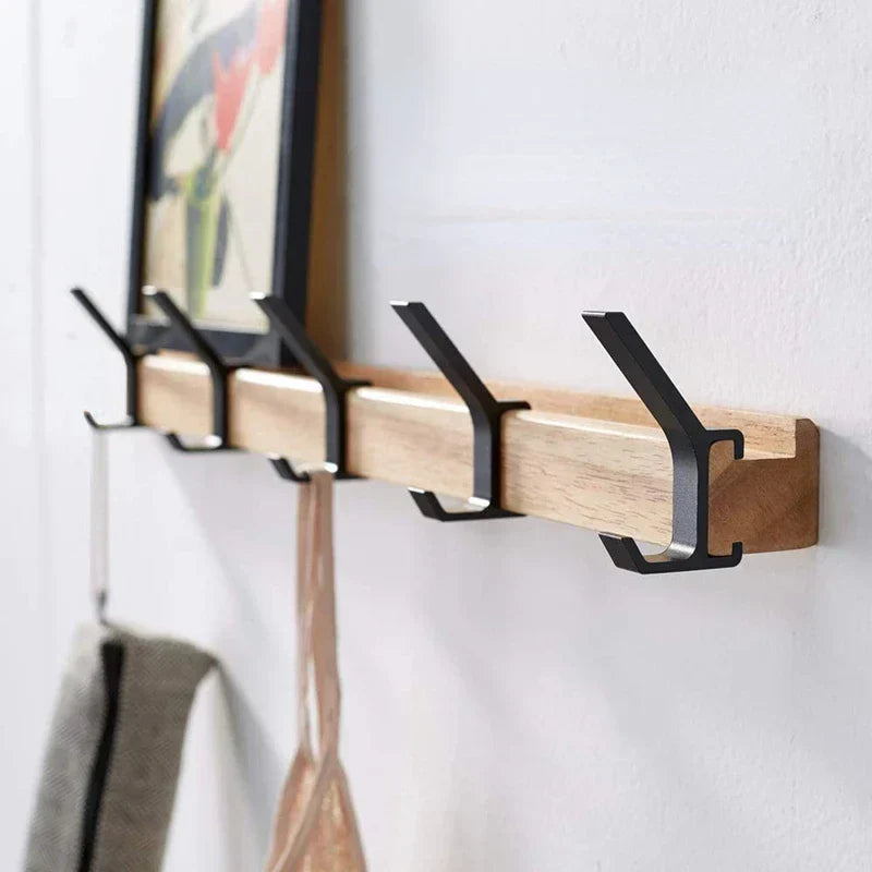 Wall-mounted coat rack with black hooks and a wood-effect bar