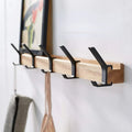 Wall-mounted coat rack with black hooks and a wood-effect bar