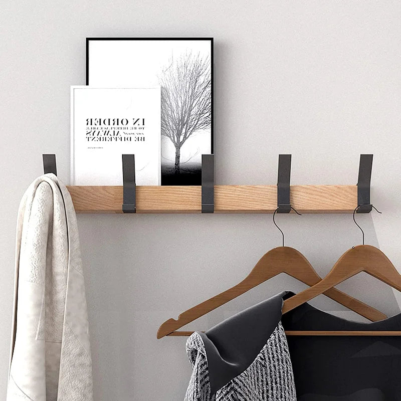 Wall-mounted coat rack with black hooks and a wood-effect bar